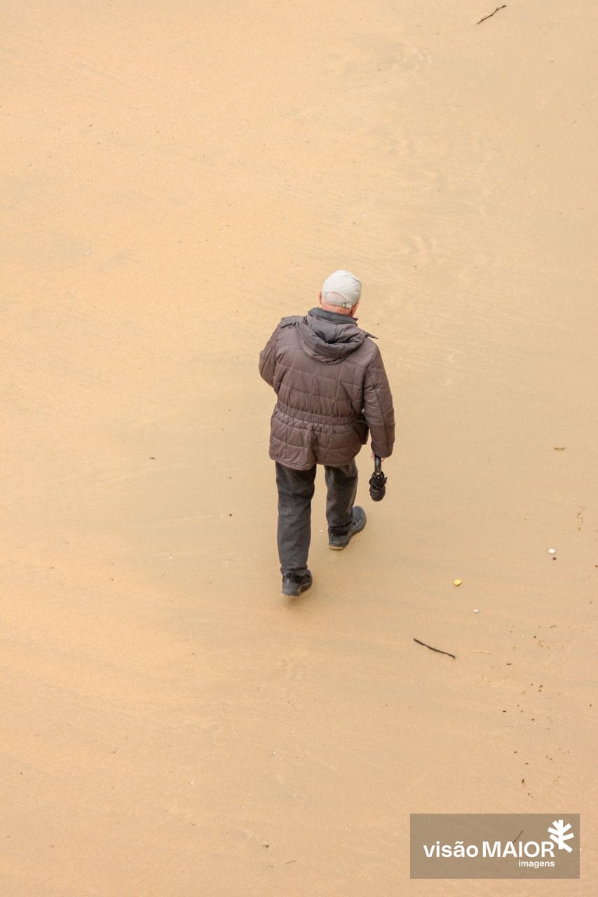 Um homem a caminhar na praia