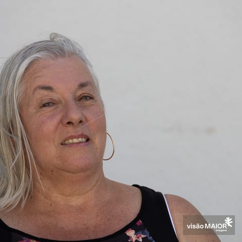 Mulher de cabelos brancos e brincos com cabelo ao vento
