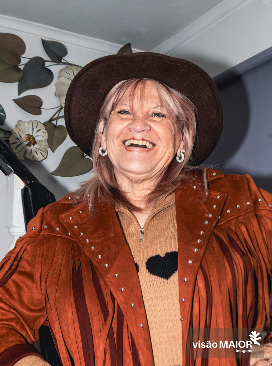 Mulher a rir de casapo de cabedal e chapeu, de cabelo e olhos claros
