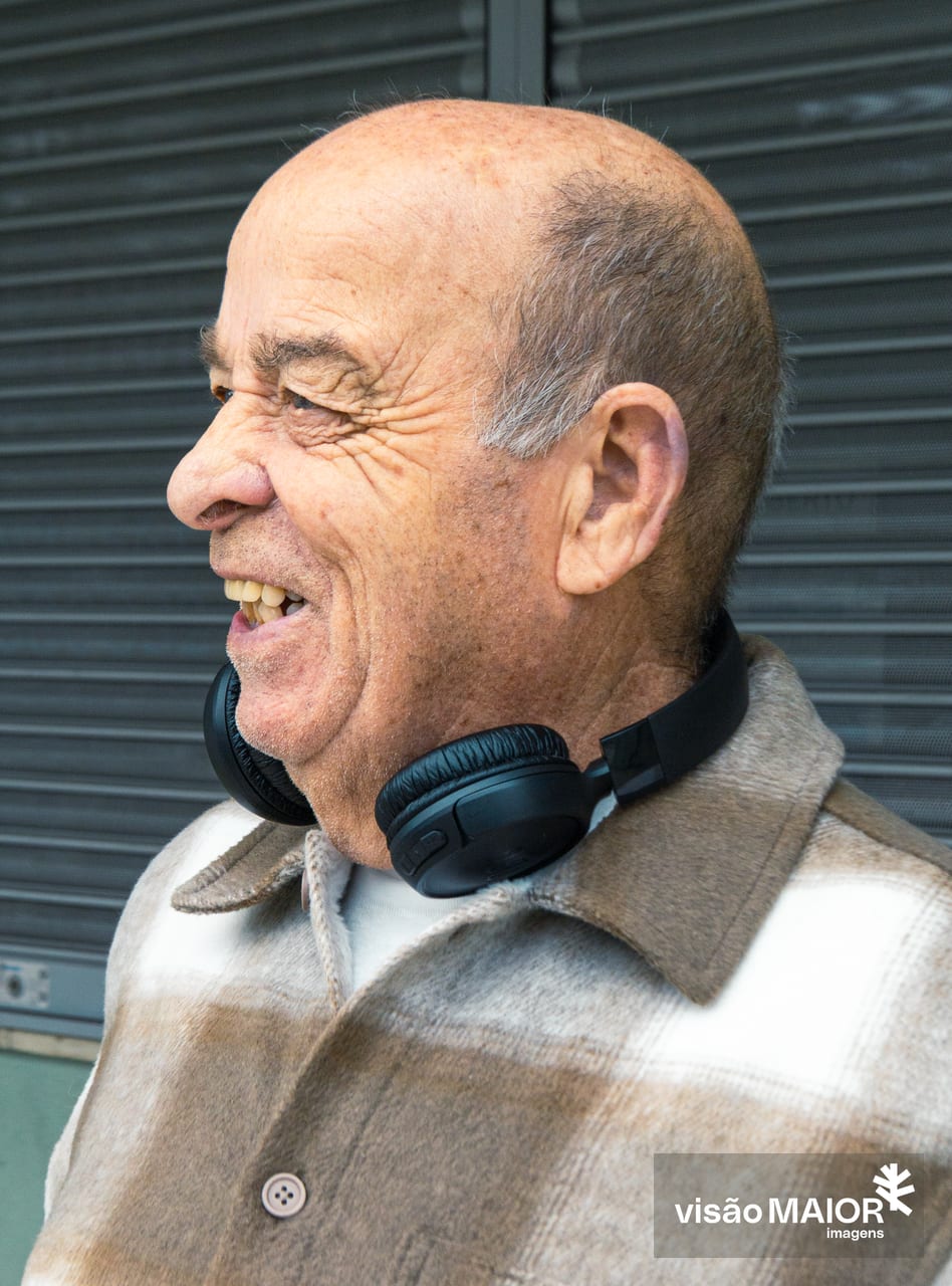 Homem careca de perfil, com headphones à volta do pescoço