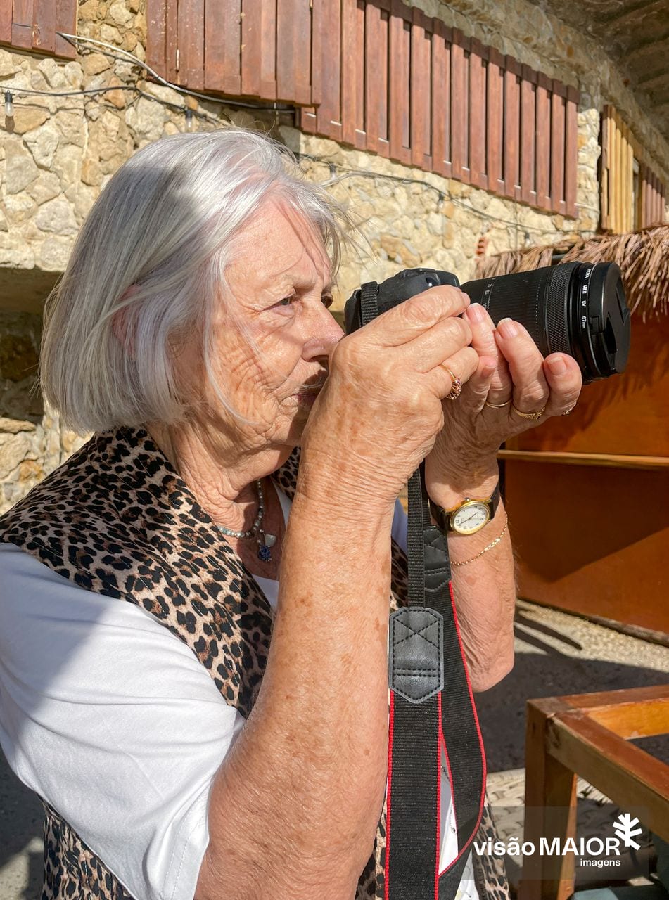 Mulher de perfil, cabelos brancos e aneis a tirar fotografias
