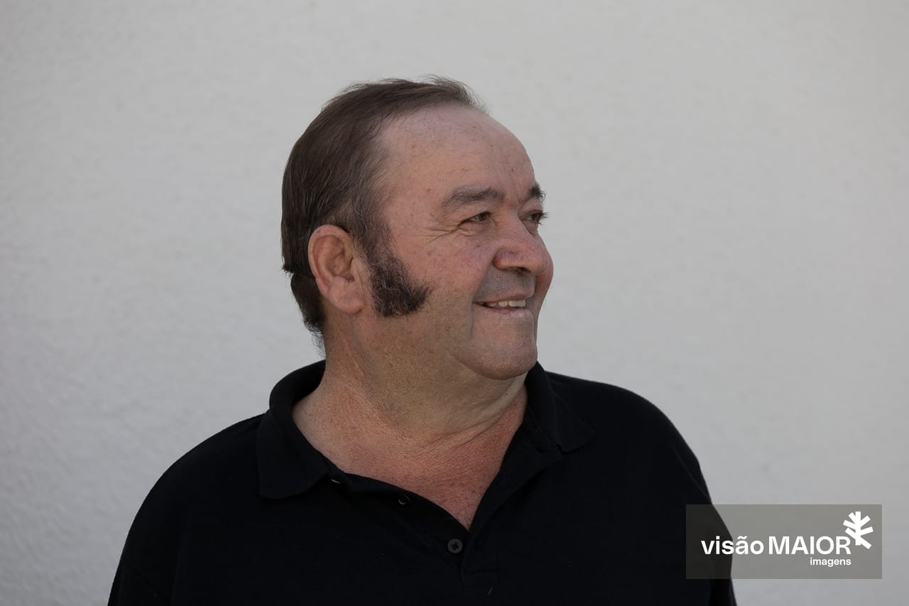 Homem ce cabelo castanho com patilhas a olhar de lado em perfil